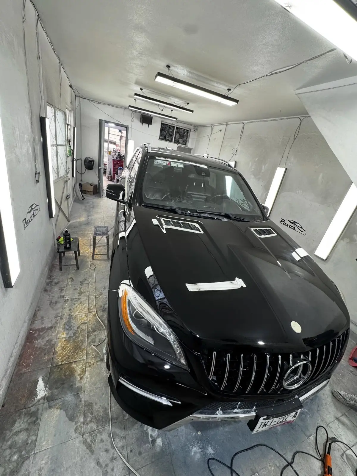 Vehículo BMW negro con acabado brillante dentro del taller